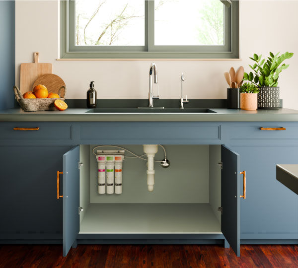 RC100 Circle Reverse Osmosis Water Filtration System installed under sink, compact and sleek design with open cabinet showcasing modern kitchen setup.