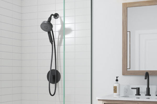 Nebia Yuba Handshower with HaloNetic Double Docking System mounted on white tile in a sleek bathroom with vanity and mirror.