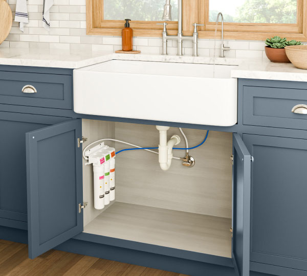 Coral Three-Stage Under Sink Water Filtration System neatly installed inside a kitchen cabinet, delivering cleaner, better-tasting water while staying hidden and space-saving.