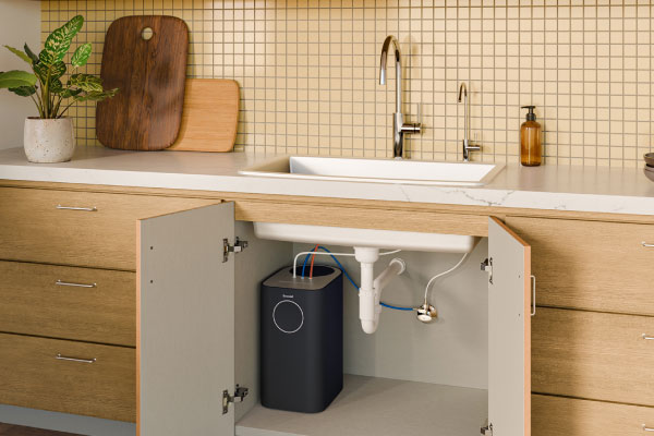 Modern kitchen sink cabinet with Circle Reverse Osmosis Water Filtration System installed below, showing compact design, clean plumbing setup, and organized under-sink storage space.
