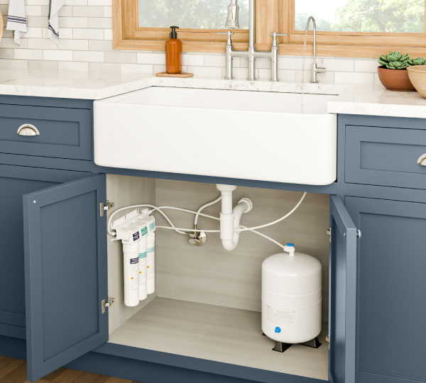 Capella Reverse Osmosis Water Filtration System installed under a modern kitchen sink with green cabinets and wood countertops, highlighting sleek, compact design.